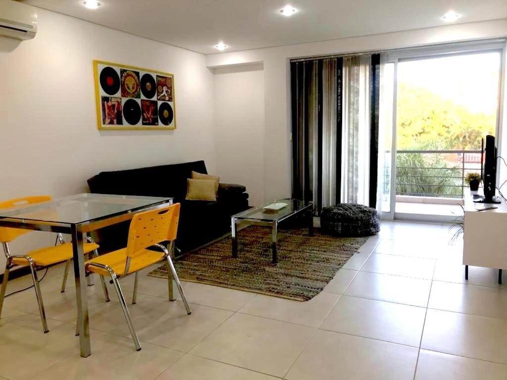 uma sala de estar com uma mesa e um sofá em Zona shopping del Sol, Asunción em Assunção