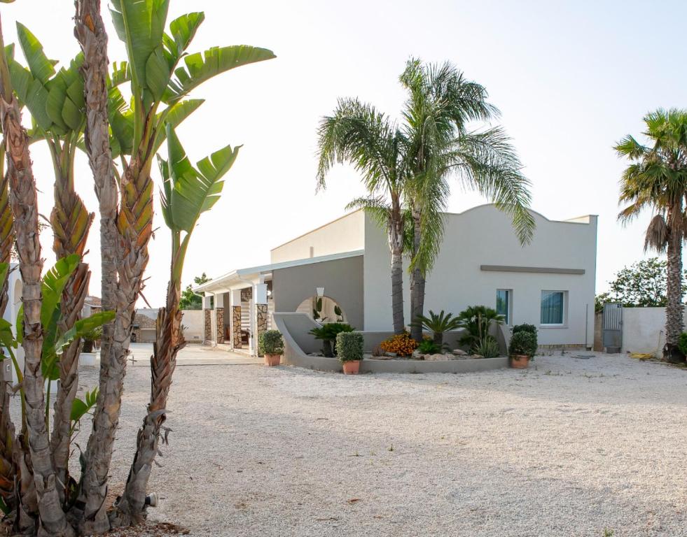 una casa con palmeras delante en Casa Vacanze Il Vigneto, en Marsala