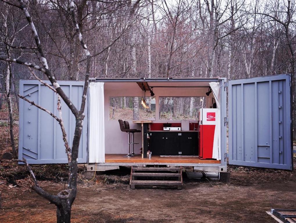 a shipping container with its door open next to a red refrigerator at Pre Hub Tokachi 