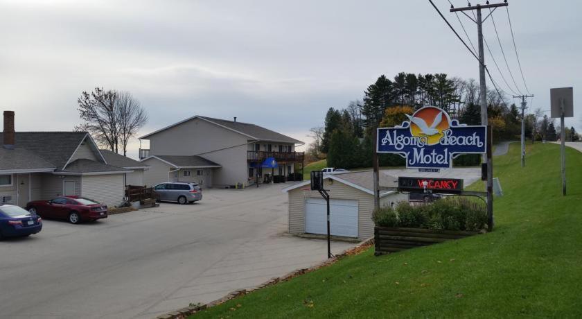 um sinal para um motel ao lado de uma rua em Algoma Beach Motel em Algoma