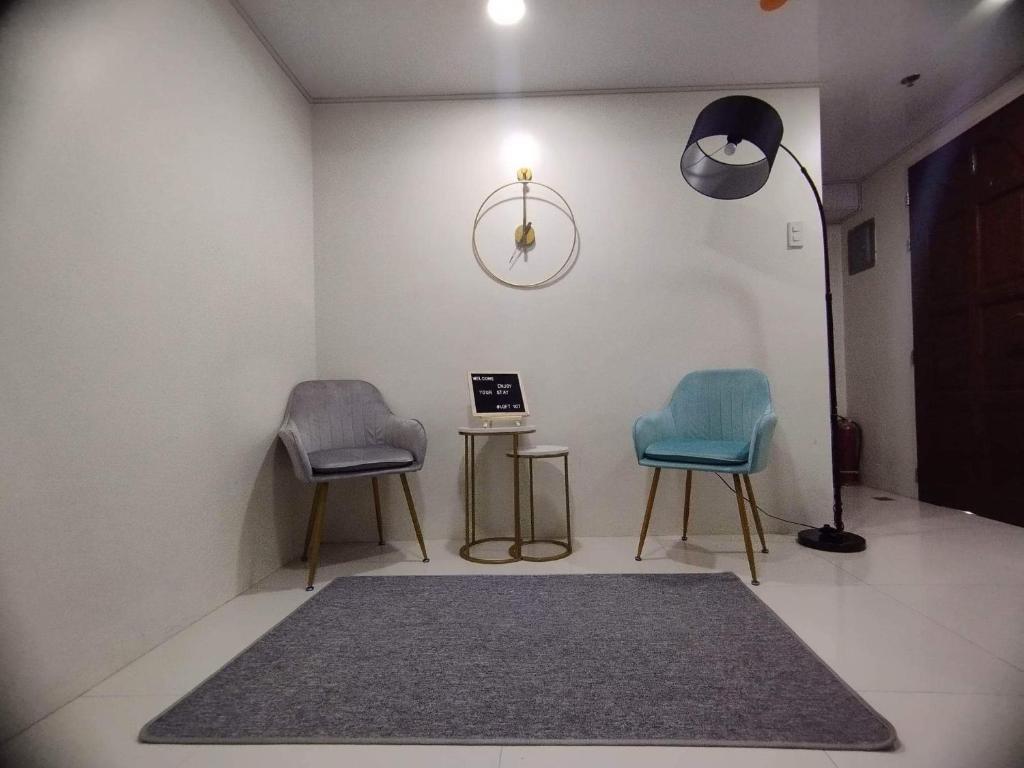 twee stoelen en een tafel in een kamer met een tapijt bij Minimalist Loft 107 in Baguio