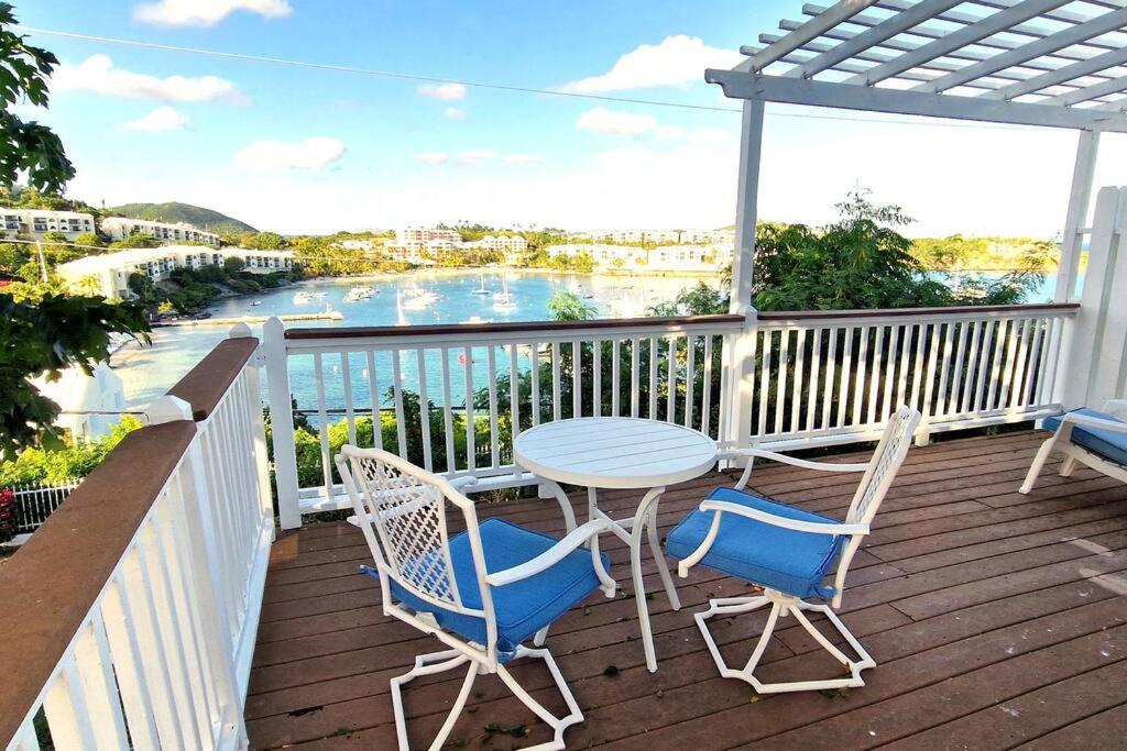 a table and chairs on a deck with a view of the water at Cozy Beachfront Apartment with Bay views in East End