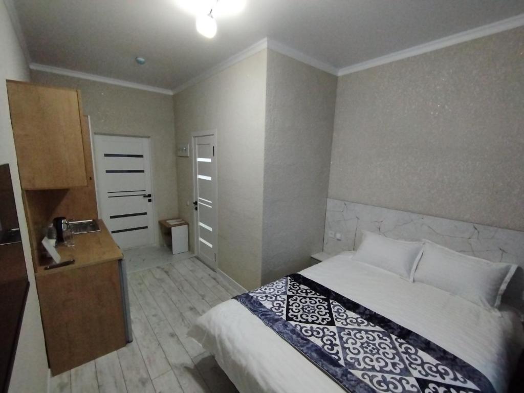 um quarto com uma cama, uma cómoda e uma porta em Pravda em Bishkek