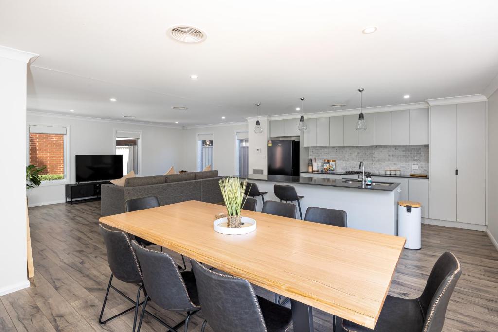 a dining room and kitchen with a table and chairs at Contemporary Living in the CBD in Wagga Wagga