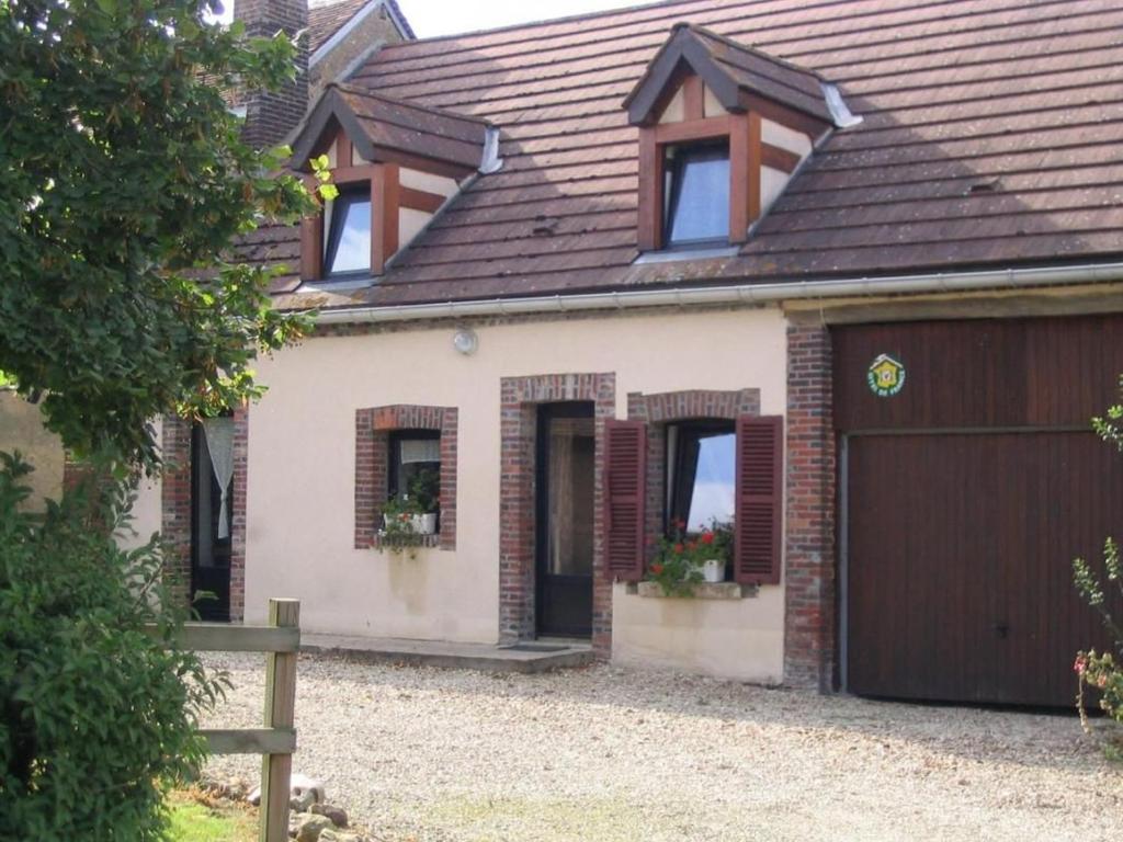 uma casa independente com uma garagem e uma cerca em Gîte Douchy-Montcorbon-Douchy, 5 pièces, 7 personnes - FR-1-590-49 