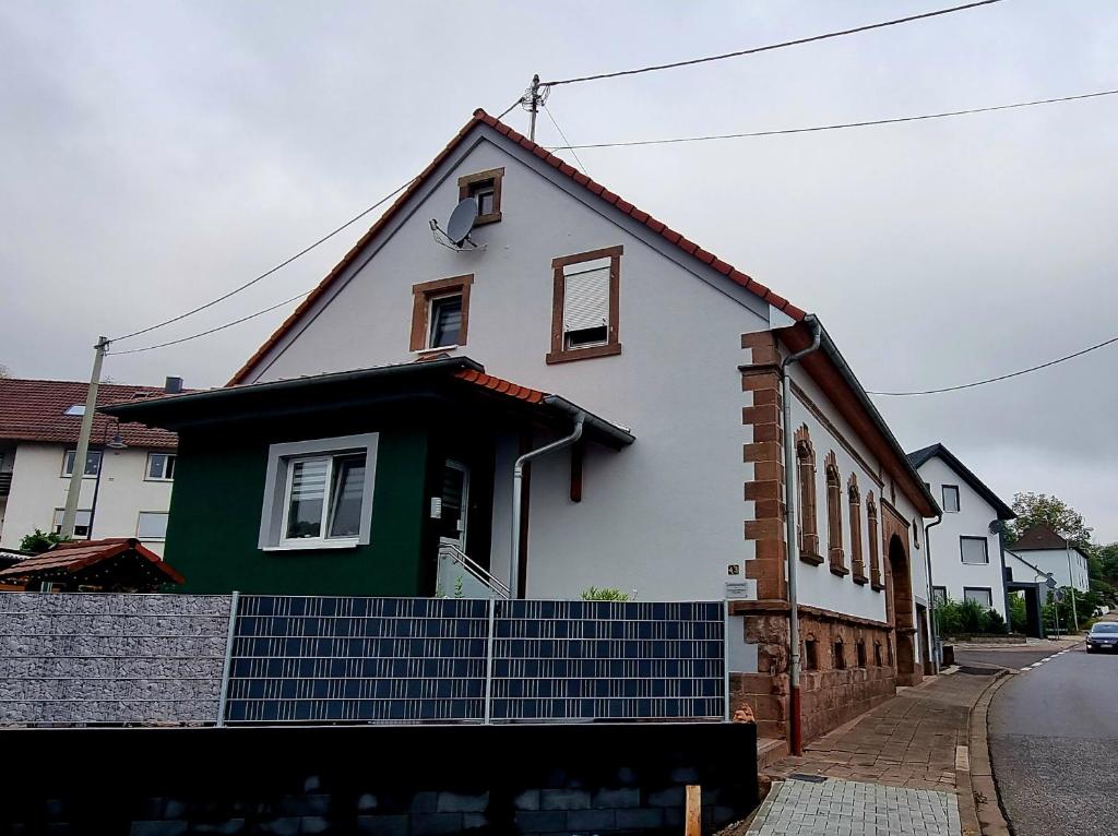 een wit en groen huis met blauwe trappen ervoor bij Ferienwohnung Otschik in Glan-Münchweiler