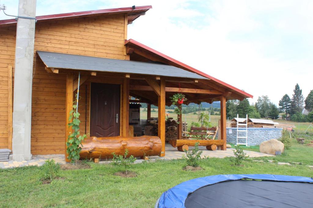 uma cabana de madeira com um alpendre com um alpendre em Chatka Pod Bukovkou em Cervena Voda