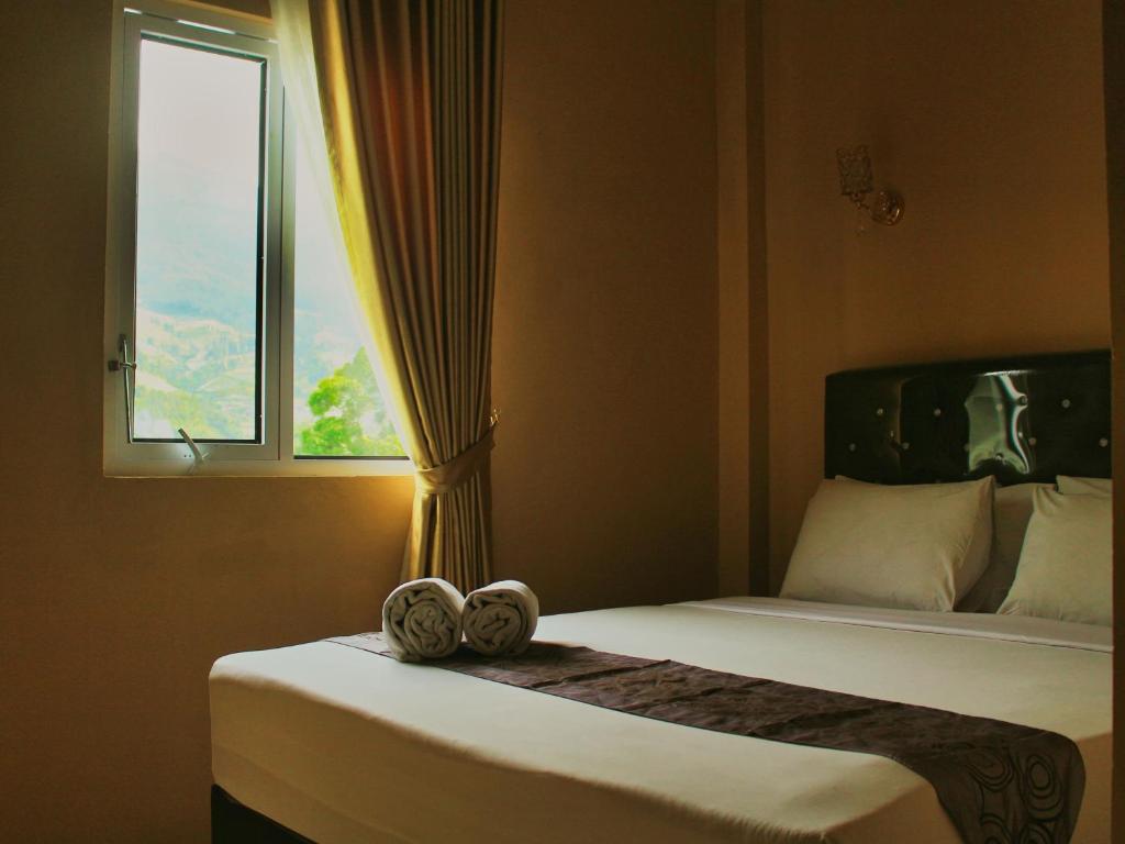 a bedroom with a bed with two towels on it at Tree Love Temanggung Hotel in Parakan