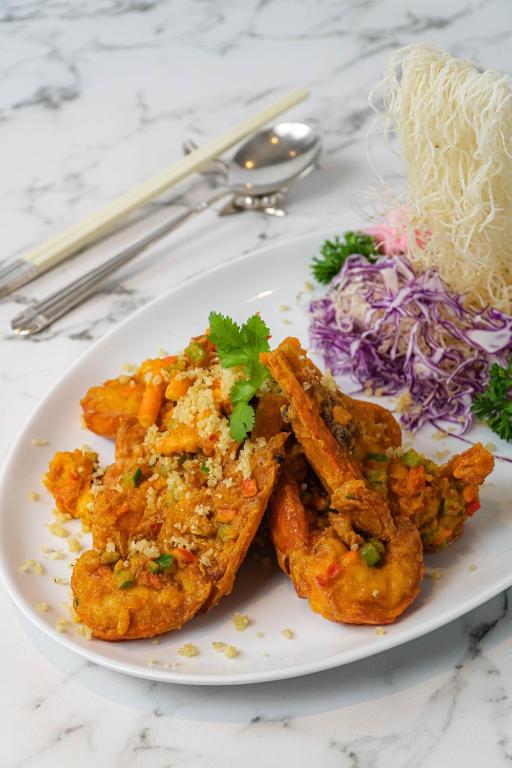 A plated fried seafood dish with shredded vegetables on a marble-pattern table.