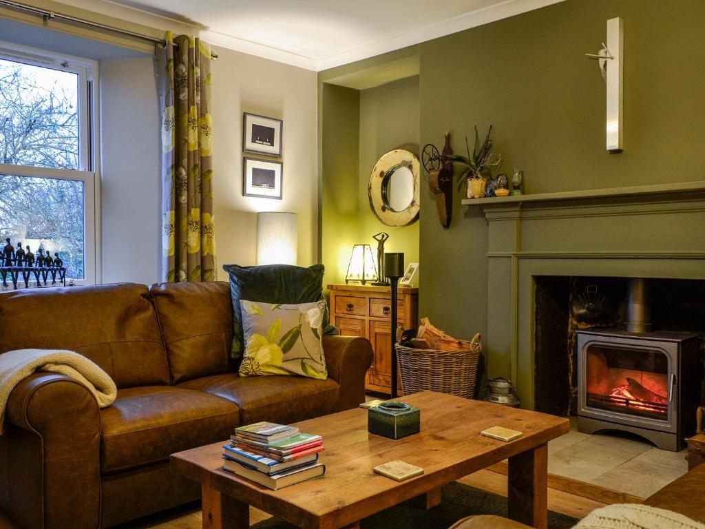 a living room with a couch and a fireplace at Cotlea East Cottage in Alyth