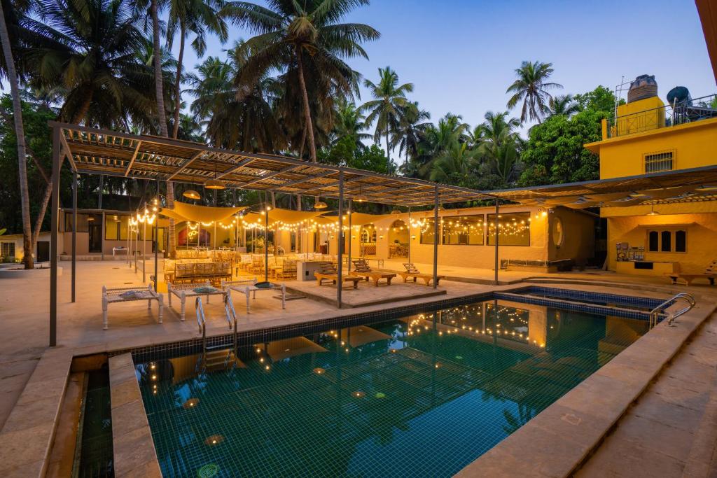 una piscina frente a una casa en Zostel Goa, Morjim, en Morjim