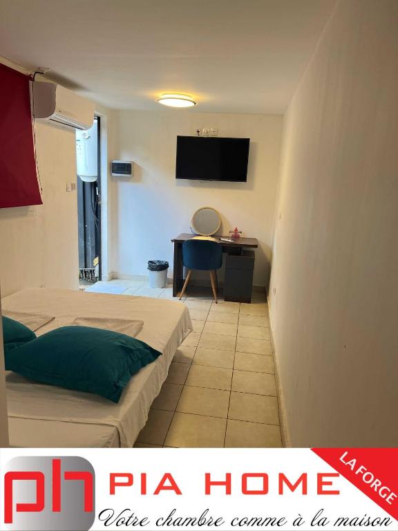 um quarto de hotel com duas camas e uma secretária em PIA HOME La Forge em Tsingoni