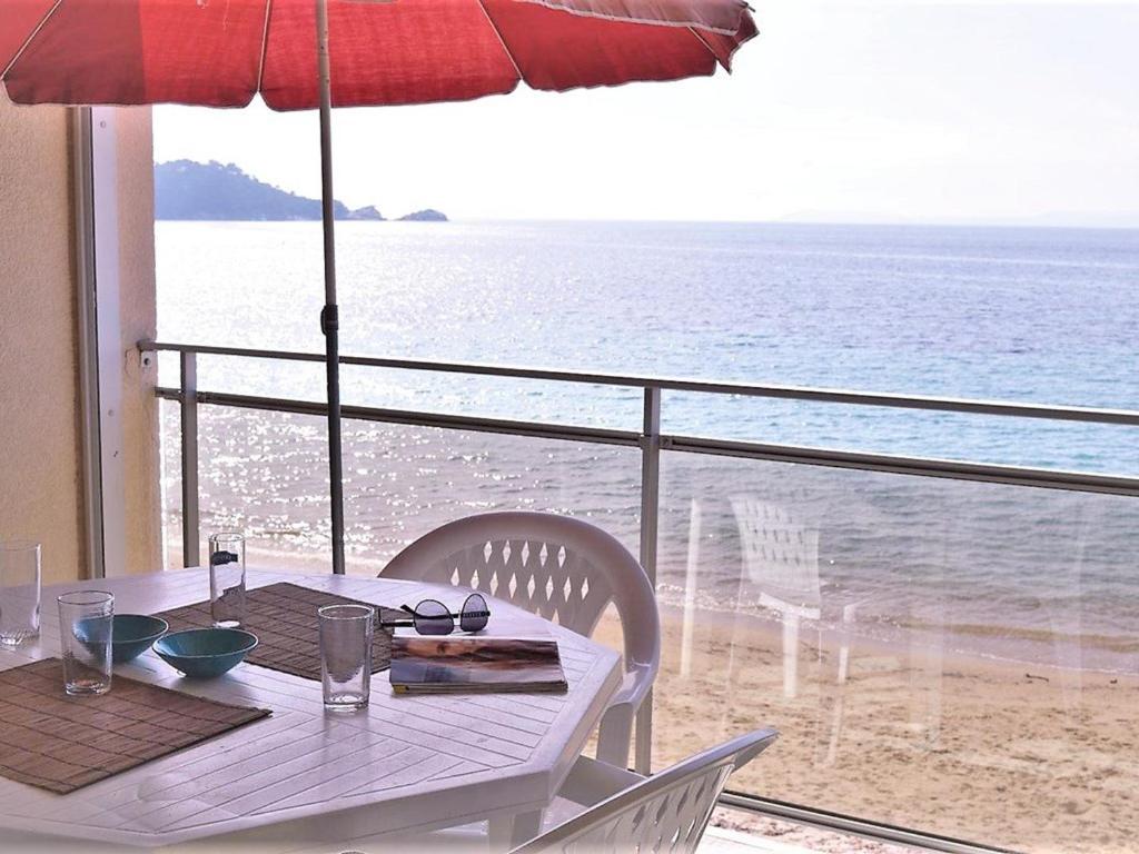 - une table avec un parasol et une vue sur l'océan dans l'établissement Appartement Cavalière, 2 pièces, 5 personnes - FR-1-251-138, au Lavandou