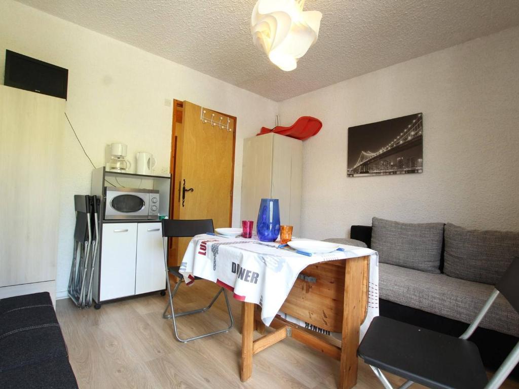 a small living room with a table and a couch at Studio à Serre-Chevalier avec Parking, Wifi et Local à Ski - FR-1-330E-65 in Serre Chevalier