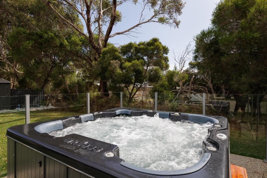 a hot tub with water in it in a yard at Cowes Family Beach House in Cowes