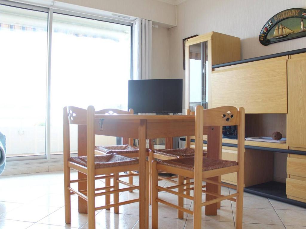 uma mesa de jantar com 2 cadeiras e uma televisão em Appartement La Baule, 1 pièce, 4 personnes - FR-1-245-133 em La Baule