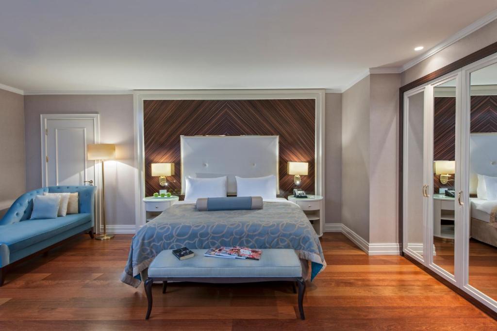 a bedroom with a bed and a blue couch at Elite World Istanbul Florya in Istanbul