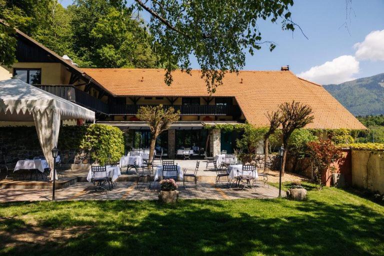 un patio con mesas y sillas frente a una casa en Vila Podvin, en Radovljica