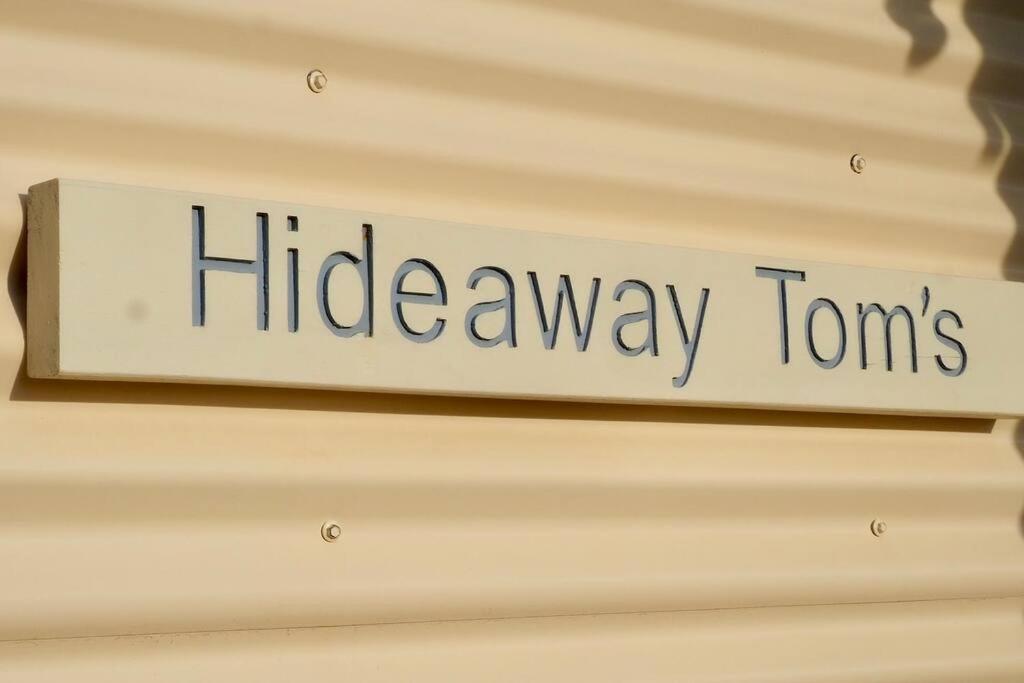 una señal que lee viajes ocultos colgando de una pared en Hideaway Tom’s on Mundoo Channel - Waterfront, en Hindmarsh Island