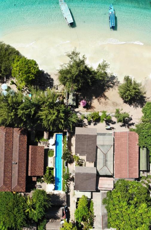 uma vista aérea de uma praia com casas e árvores em The Yoga Garden em Gili Trawangan