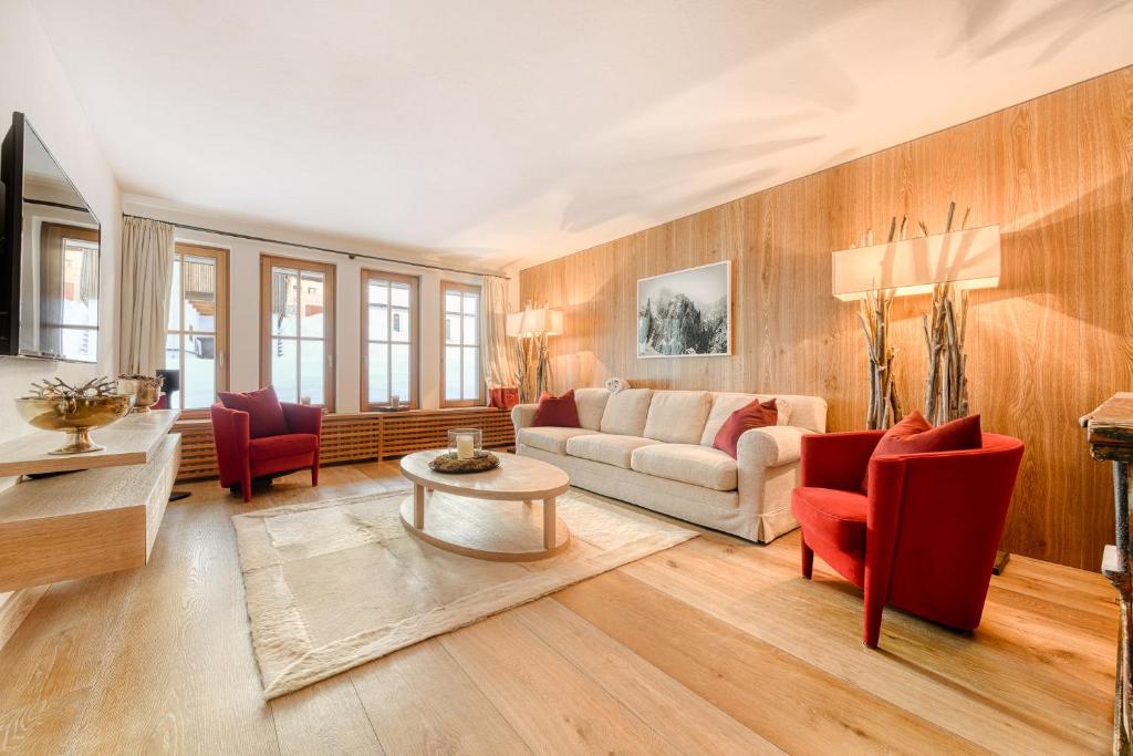 a living room with a couch and red chairs at Chalet Lilly - Family and Friends by A-Appartments mit Ski in - Ski out in Zug