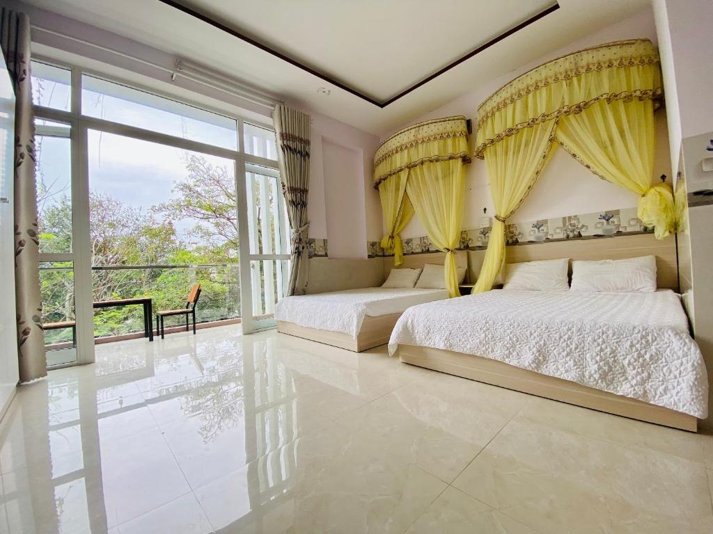 a bedroom with two beds and a large window at gau homestay in Tuy Hoa