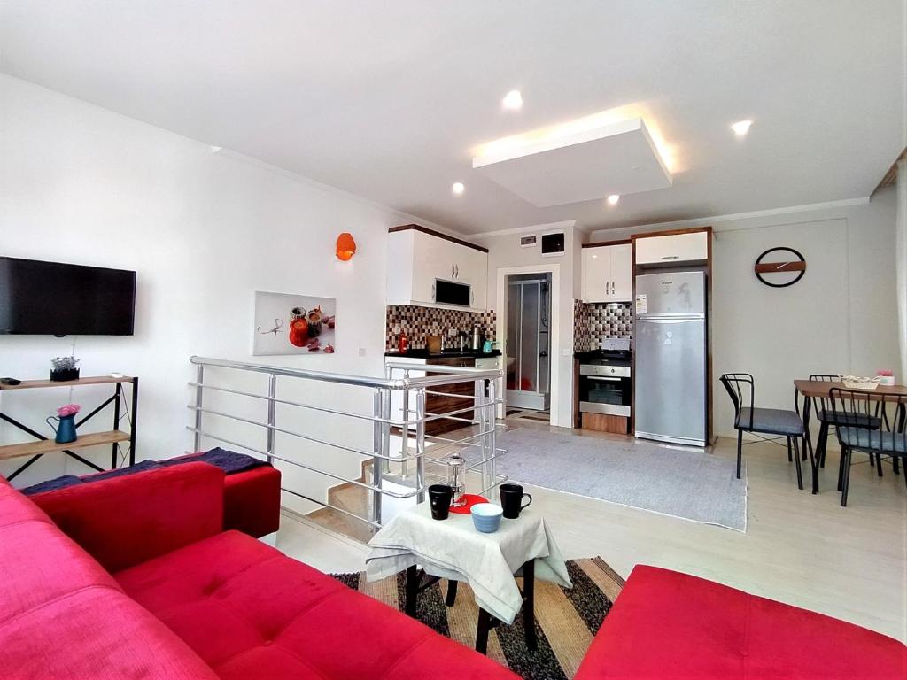 ein Wohnzimmer mit einem roten Sofa und einer Küche in der Unterkunft Sere in Antalya