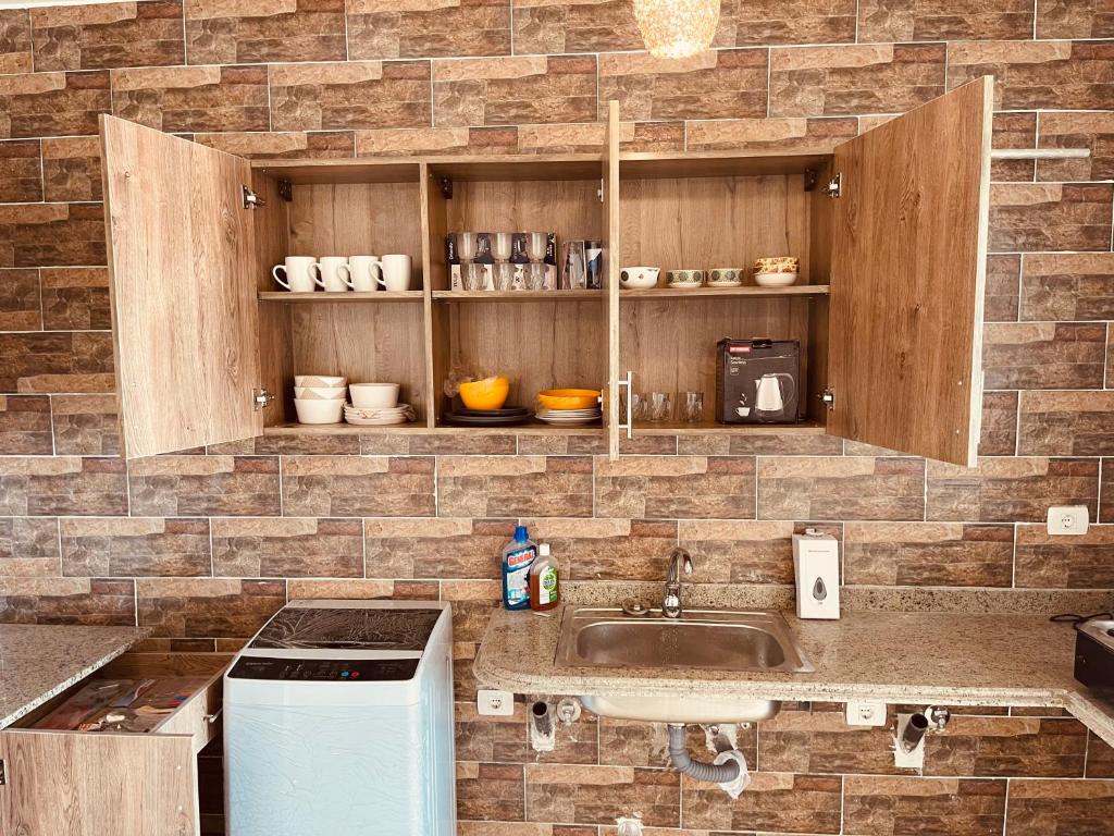 uma cozinha com um lavatório e uma parede de tijolos em شاليه فندقى سياحى em Ain Sokhna