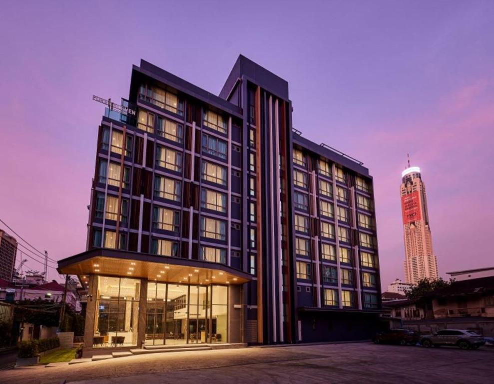 a large black building with a tall building in the background at Pure Eleven Hotel Bangkok in Makkasan