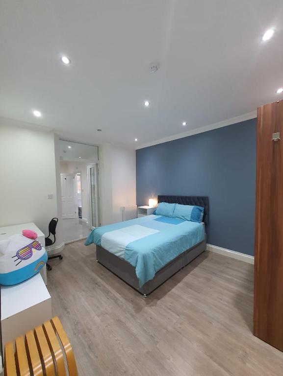 a bedroom with a bed and a blue wall at Cosy Entire Home Kingscross Central London in London