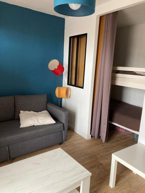 een woonkamer met een bank en een tafel bij Superbe studio à Canet en Roussillon proche de la plage in Canet-en-Roussillon