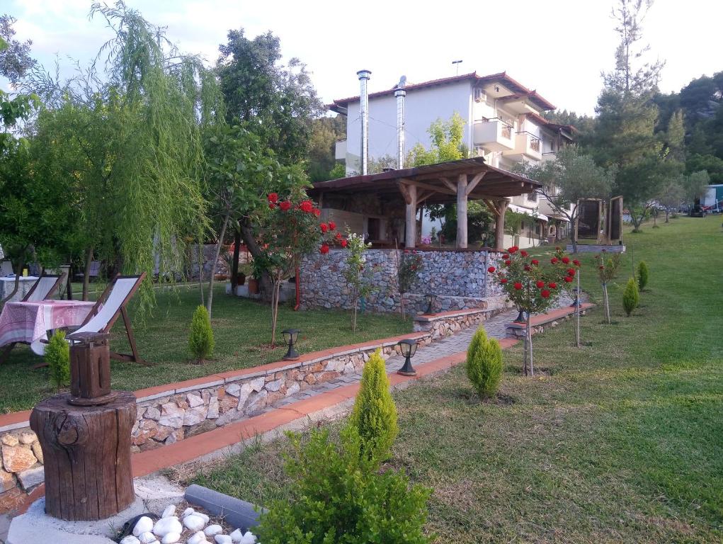 uma casa com um jardim com bancos em frente em Nikos Apartments em Ormos Panagias