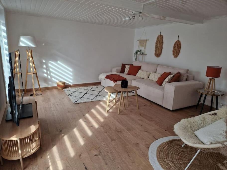 sala de estar con sofá blanco y mesa en Petite maison chaleureuse avec parking en Leuze-en-Hainaut