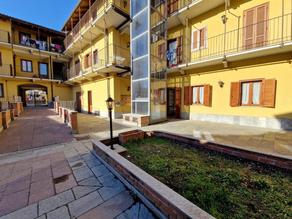 un patio vacío de un gran edificio amarillo en Il Fiocco Dla Duja di Ciriè, en Cirié