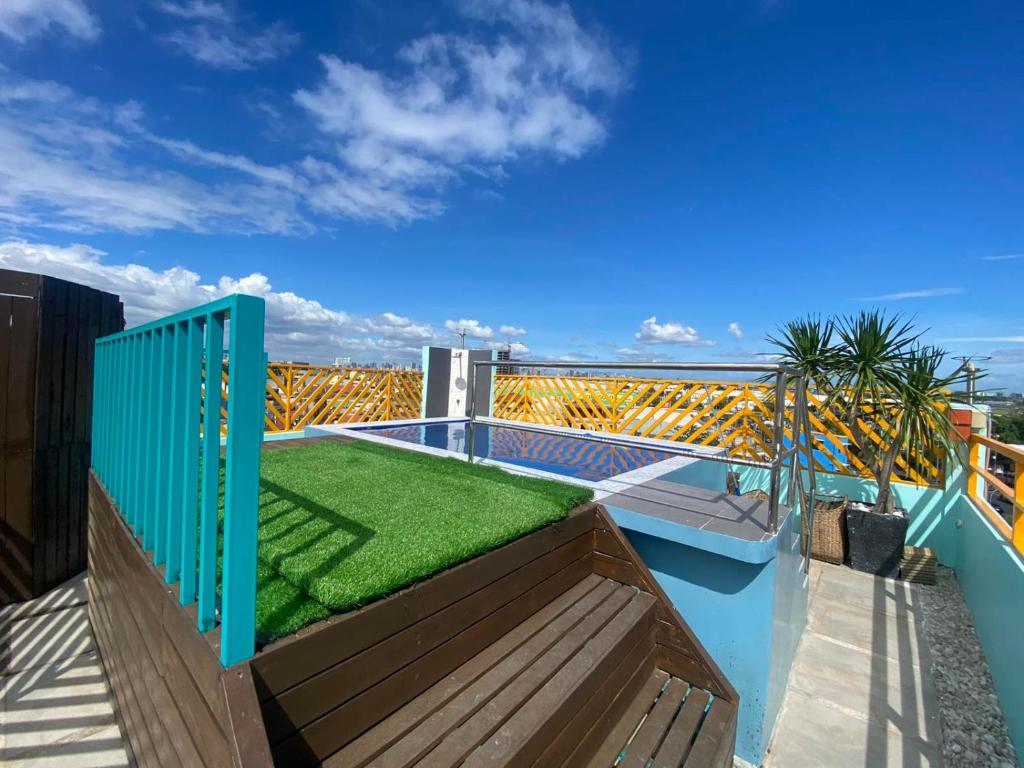 a balcony with a green lawn on top of it at Rain Airport Bed and Breakfast in Manila