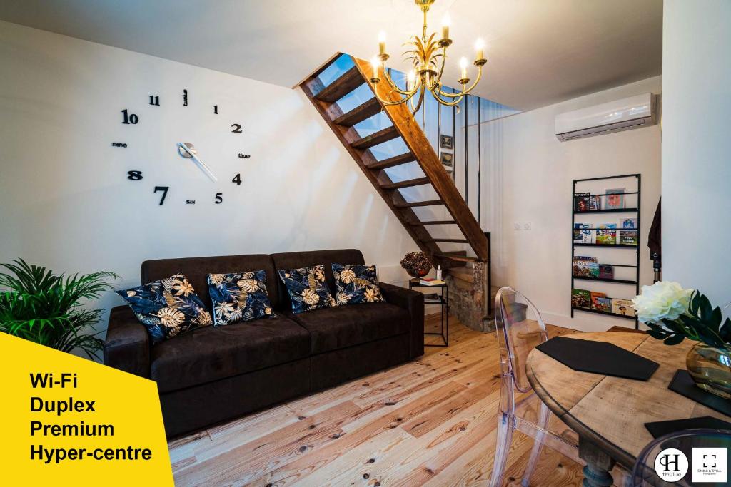 a living room with a couch and a clock on the wall at Haut 30 in Saint-Amand-les-Eaux