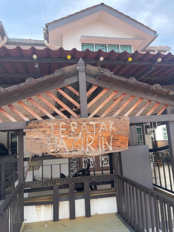 a sign on a fence in front of a building at NO 121 NAZIRIN HOMESTAY TMN DESA MANJUNG in Lumut