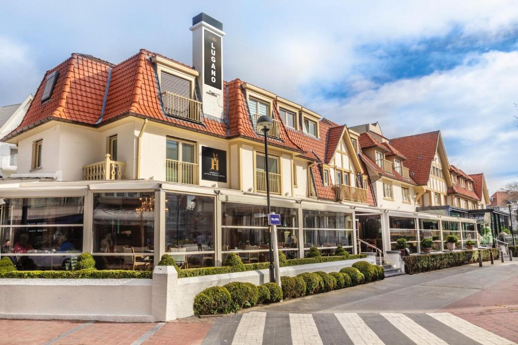 ein Hotel in einer Straße mit einem Gebäude in der Unterkunft Hotel Lugano in Knokke-Heist