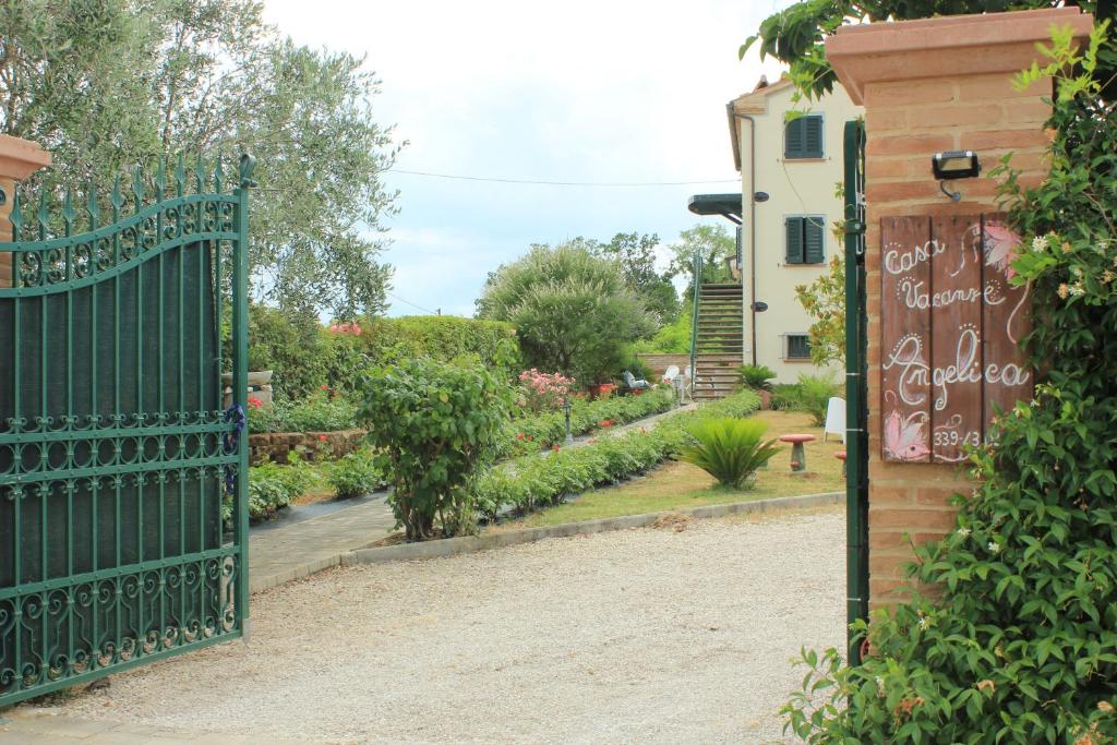 un portail vert avec un jardin en arrière-plan dans l'établissement Casa Vacanze Angelica, à Ostra Vetere