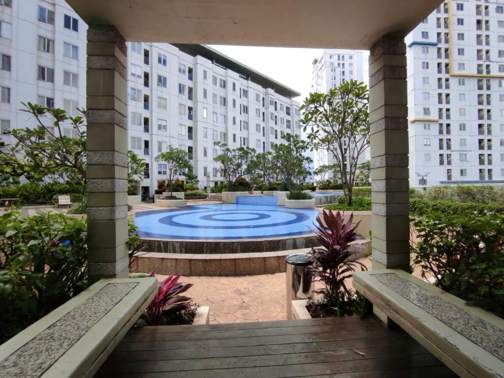 雅加達的住宿－Apartemen Bassura City by Jakarta Property，庭院中一座大型游泳池,庭院内有建筑