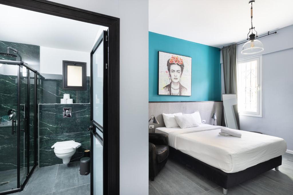 a bedroom with a bed and a bathroom with a shower at Liber Tel Aviv Sea Shore Suites BY RAPHAEL HOTELS in Tel Aviv
