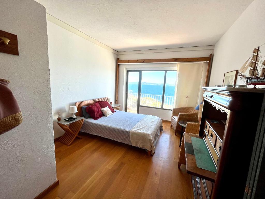 a bedroom with a bed and a large window at Apartamento con playa y vistas en la Costa Brava in Begur