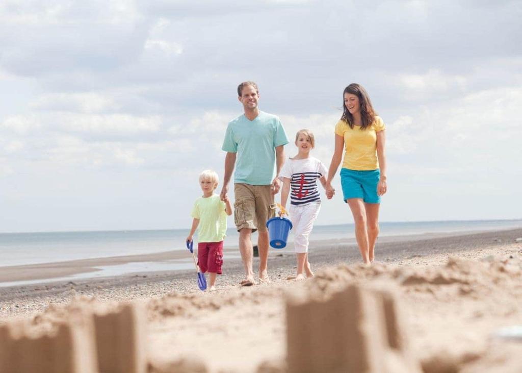 a family walking on the beach with a sand castle at Skirlington in Ulrome