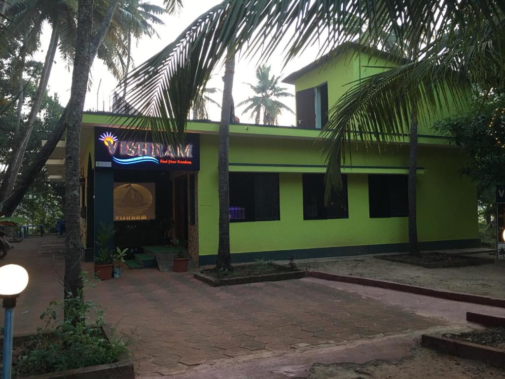 a green building with a sign in front of it at Vishram Homestay, Malpe Beach, Udupi in Malpe
