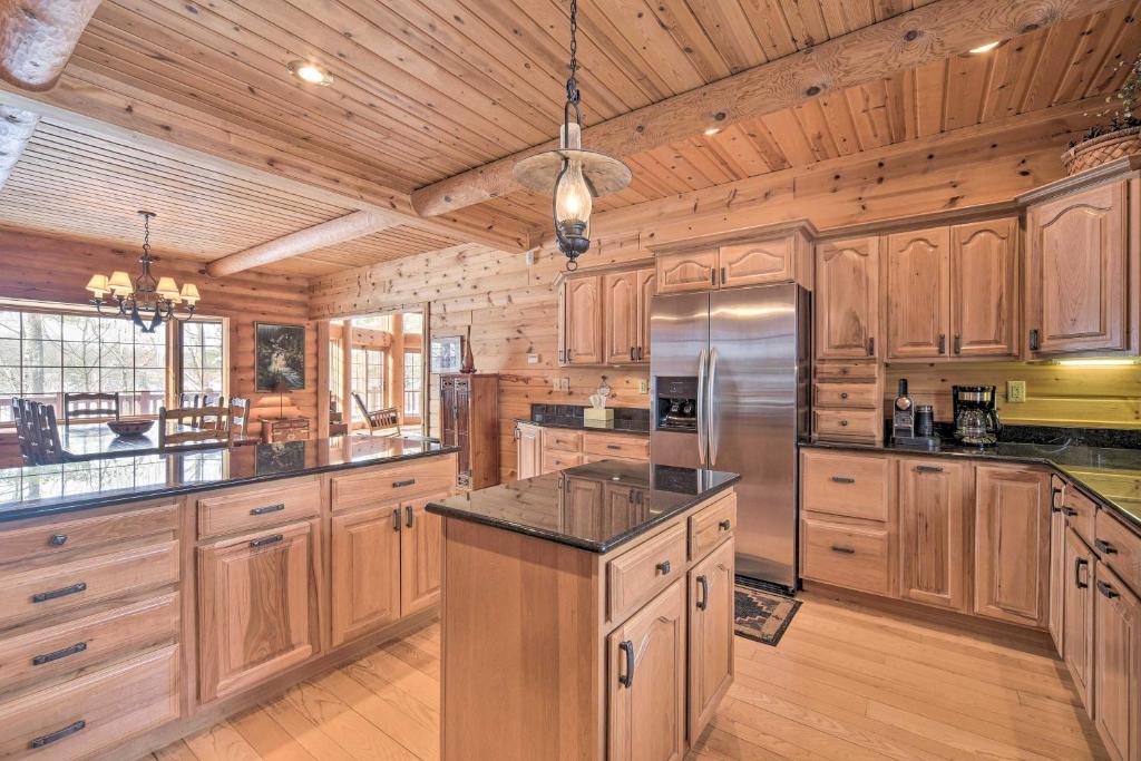 a large kitchen with wooden cabinets and a wooden ceiling at Spacious House with Boat Dock on Red Cedar Lake in Mikana