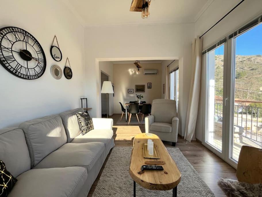 a living room with a couch and a clock on the wall at «Έλα…Δάρα» Home in Daras