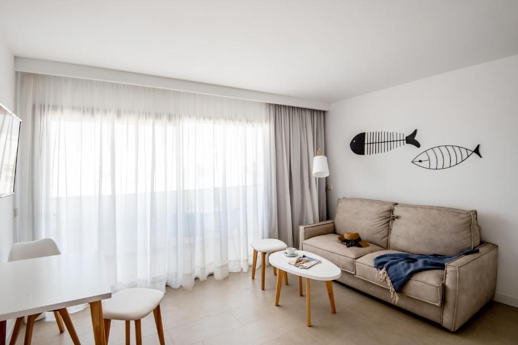 a living room with a couch and a table at Apartamentos Top Secret Prestige Es Pujols - Formentera Vacaciones in Es Pujols