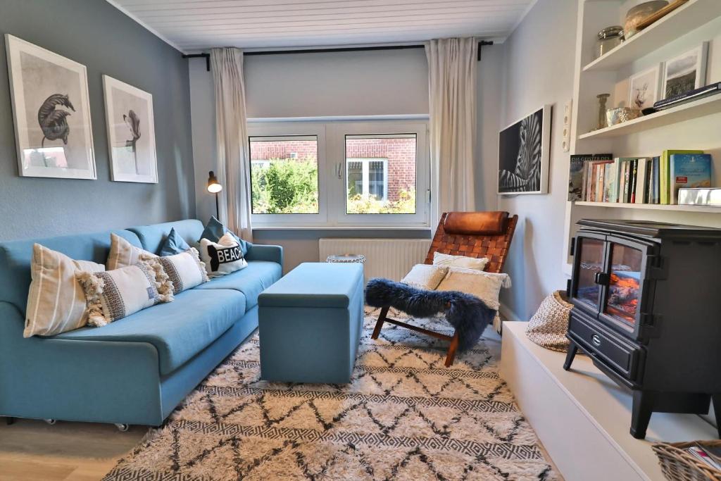 a living room with a blue couch and a fireplace at Langeooger Viermaster - Blaues Segel in Langeoog
