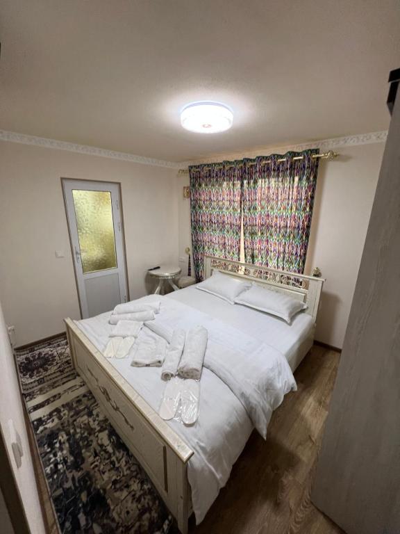 um quarto com uma grande cama branca com toalhas em Qozi Hotel em Samarkand