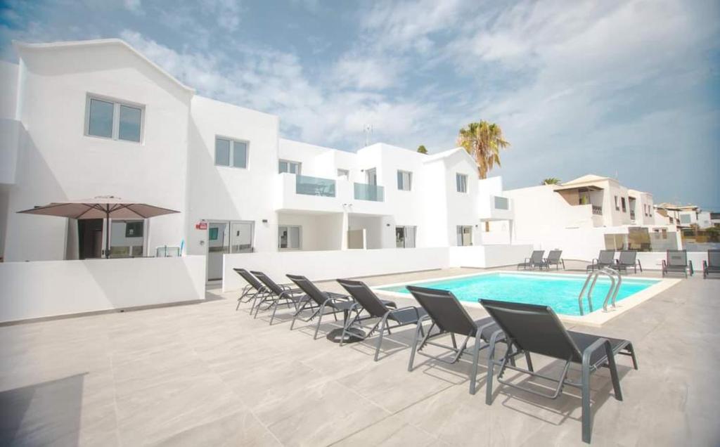 patio z krzesłami i basenem w obiekcie Rociaga 35 Apartment 8, 100 meters to sea front w Puerto del Carmen